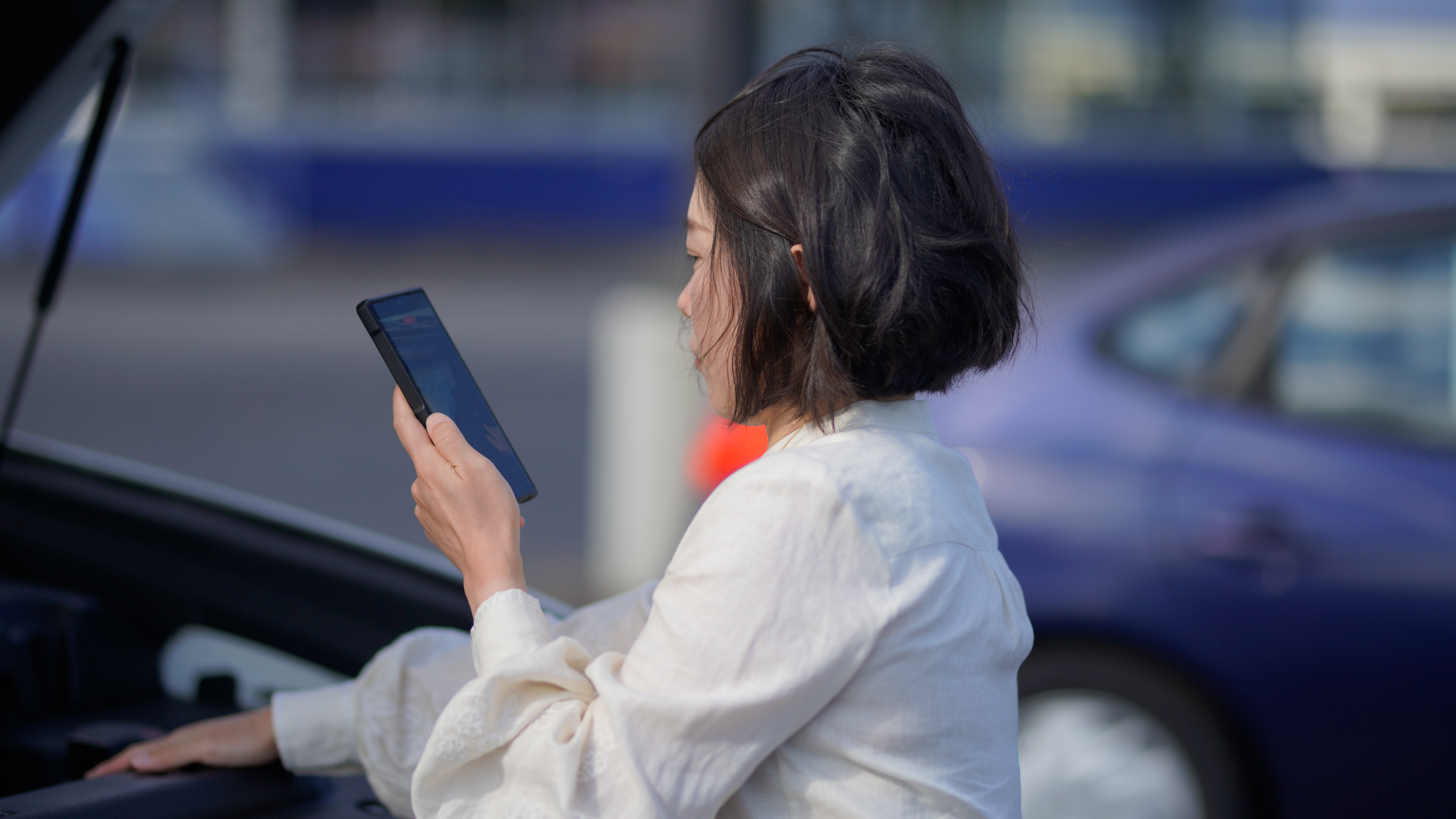 Woman using the aLex app to view her vehicle report at a dealership